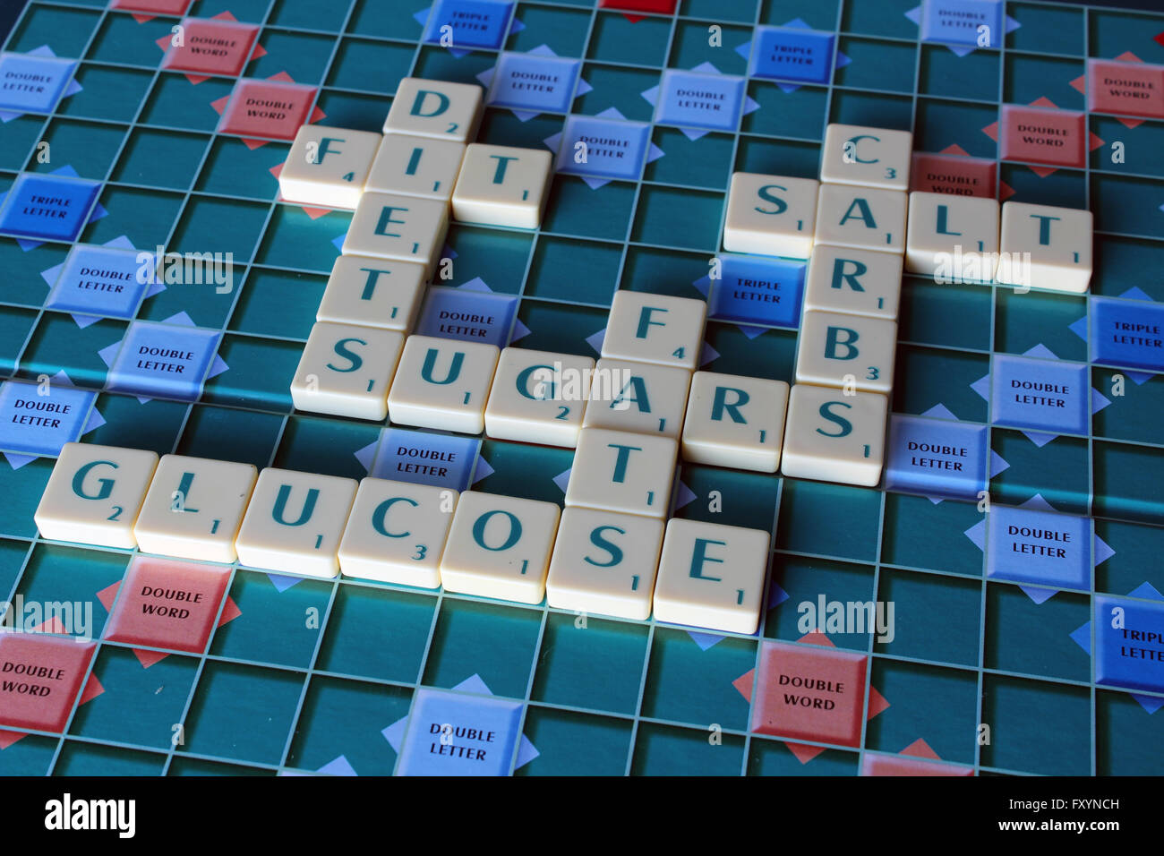 A Scrabble board with words about sugar and fattening foods Stock Photo