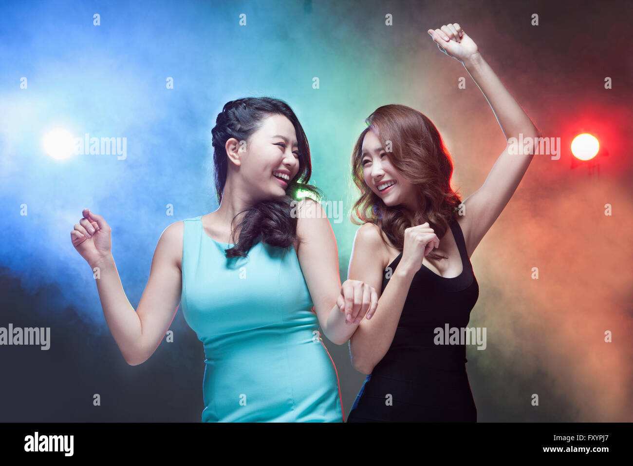 Portrait of young smiling women dancing face to face at Stock