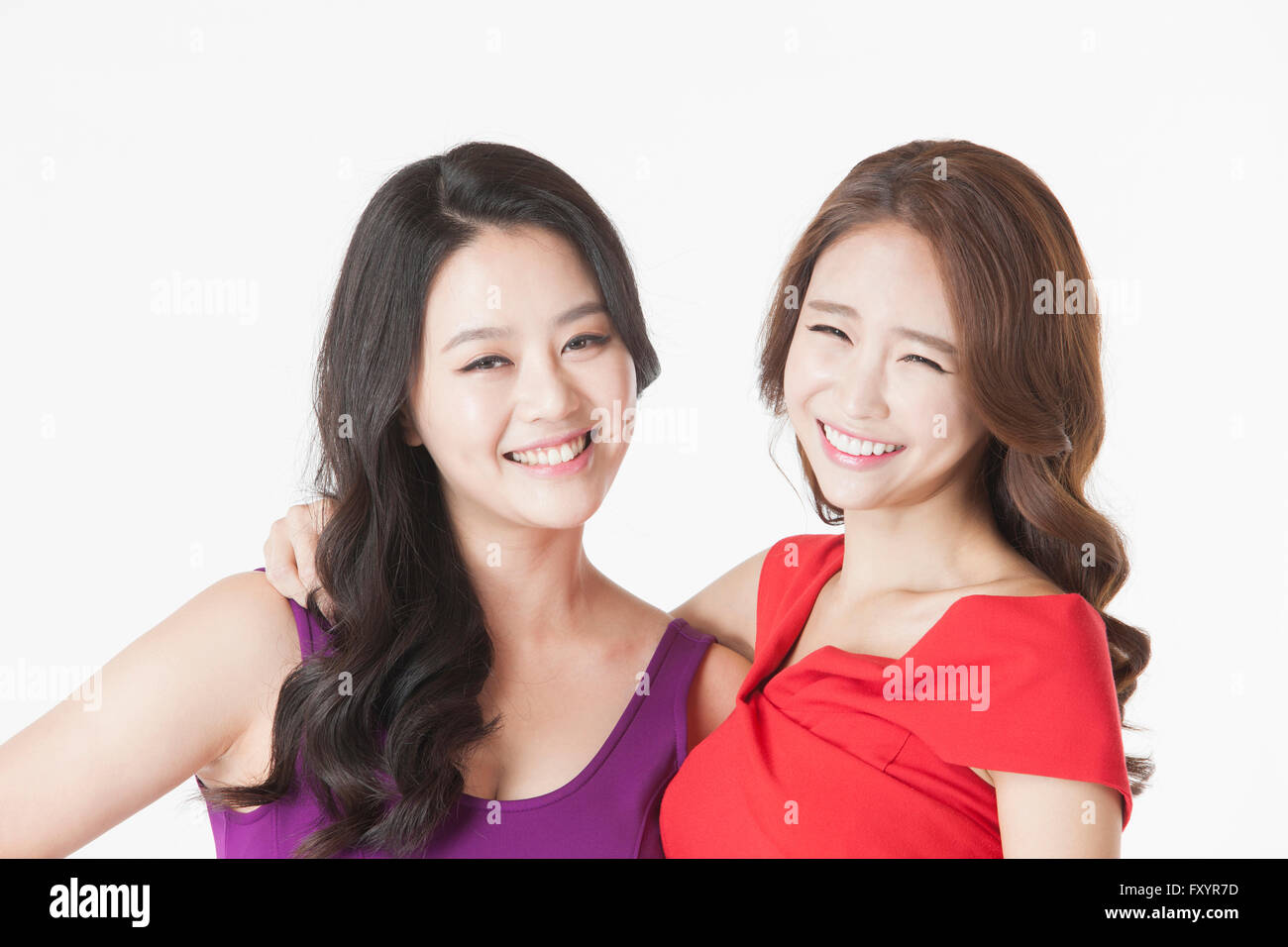 Portrait of two young smiling women staring at front Stock Photo