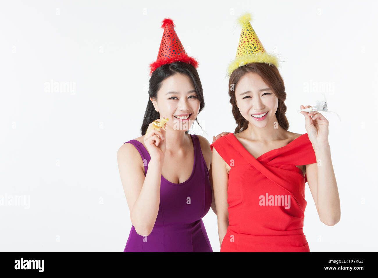Portrait of two young smiling women holding party horns at party Stock ...