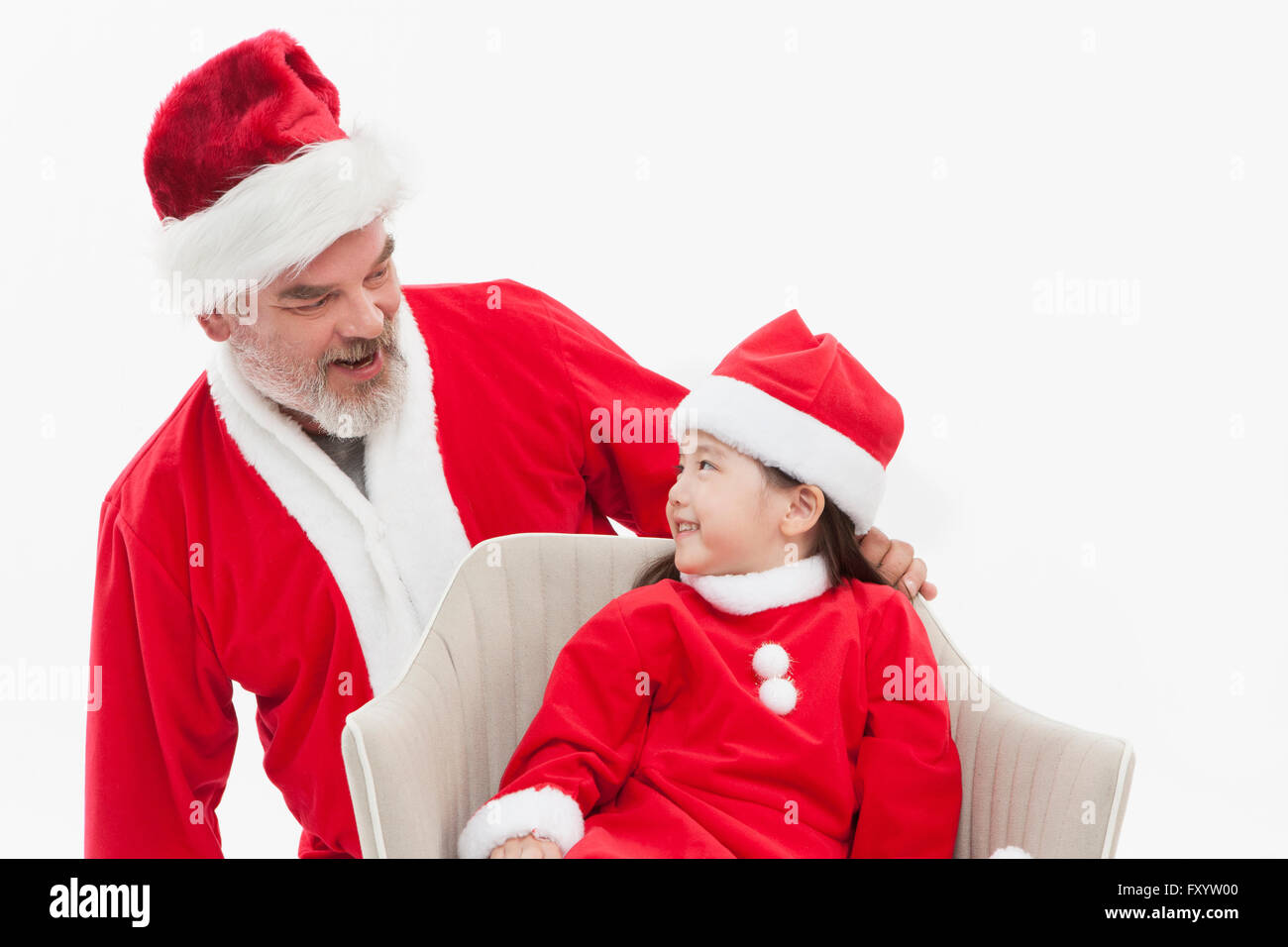 Portrait of Smiling Santa Claus and girl face to face Stock Photo