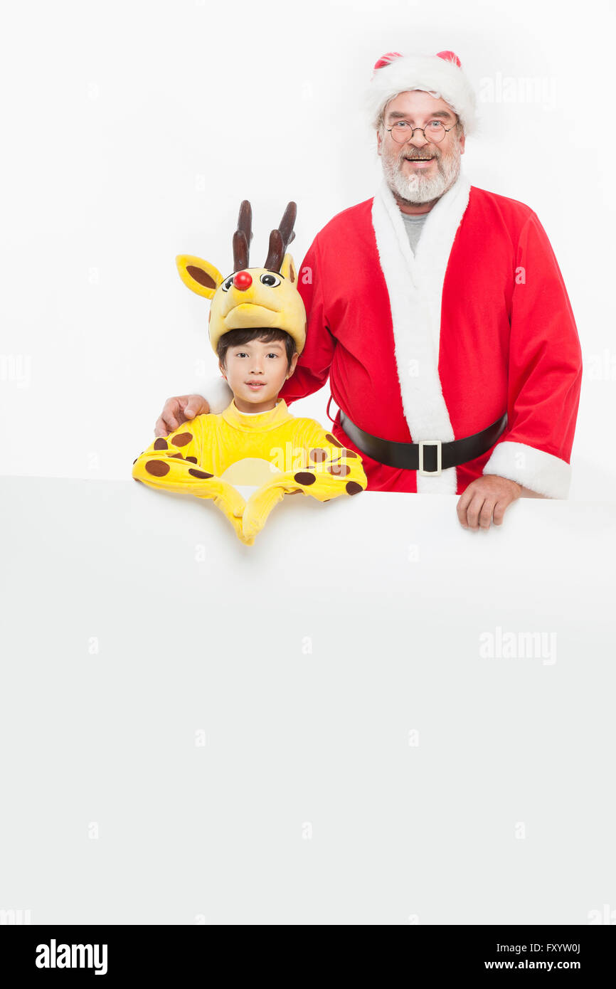 Portrait of smiling boy dressed like a deer and Santa Claus staring at front Stock Photo