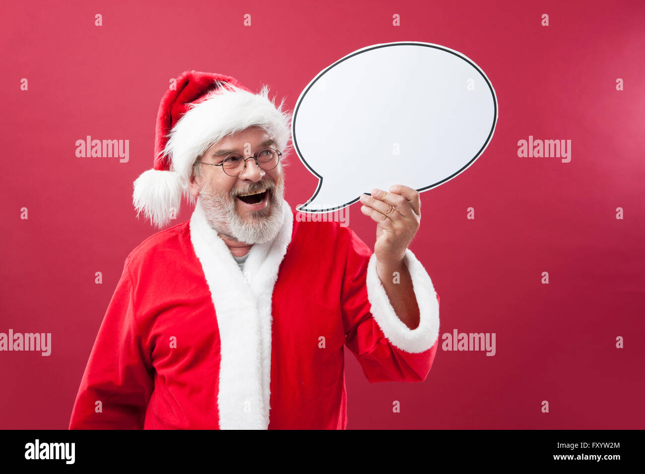 Portrait of smiling Santa Claus holding a speech balloon Stock Photo