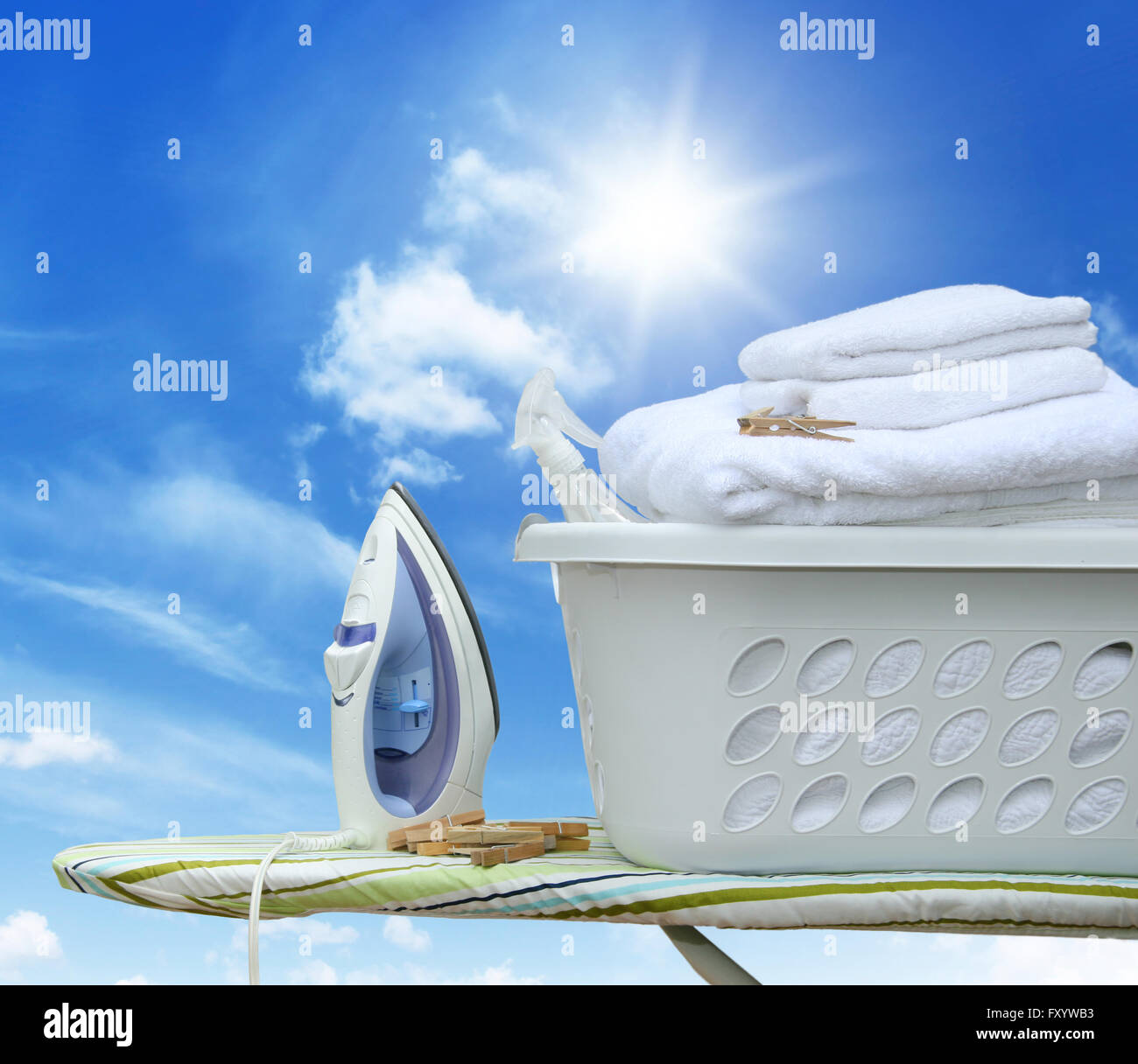 Iron on ironing board with laundry basket Stock Photo Alamy