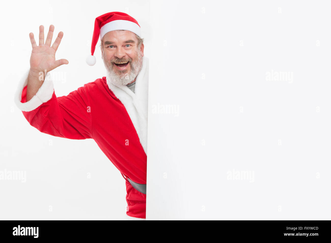 Portrait of smiling Santa waving his hand staring at front Stock Photo