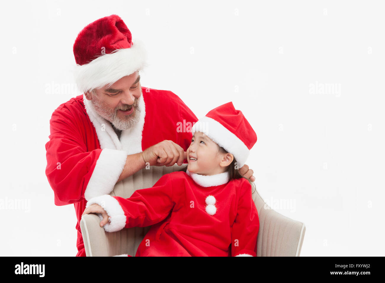 Portrait of smiling Santa and girl face to face Stock Photo