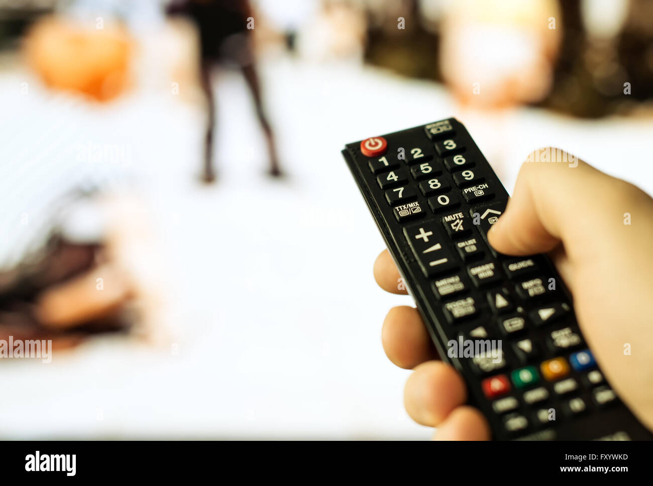 Male hand holding TV remote control Stock Photo - Alamy