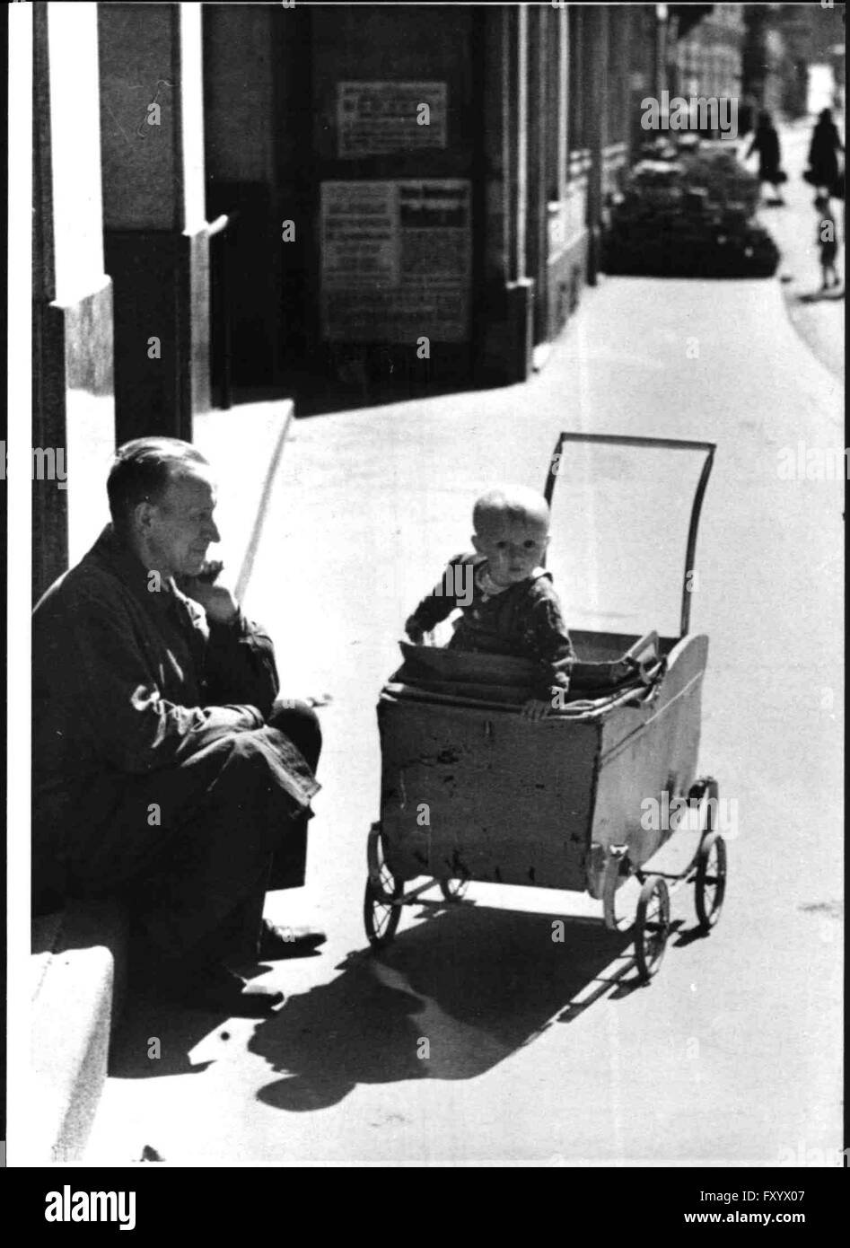 Ein Mann mit Kind im Kinderwagen im Frühjahr 1946 in Wien Stock Photo