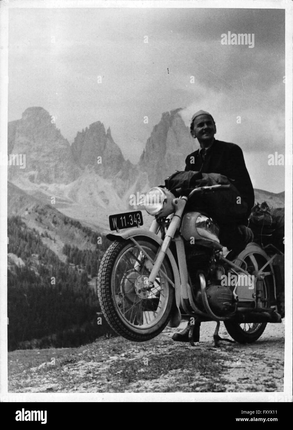 Der Fotograf Schikola mit seinem Puch-Motorrad vor einem Dolomiten-Panorama Stock Photo