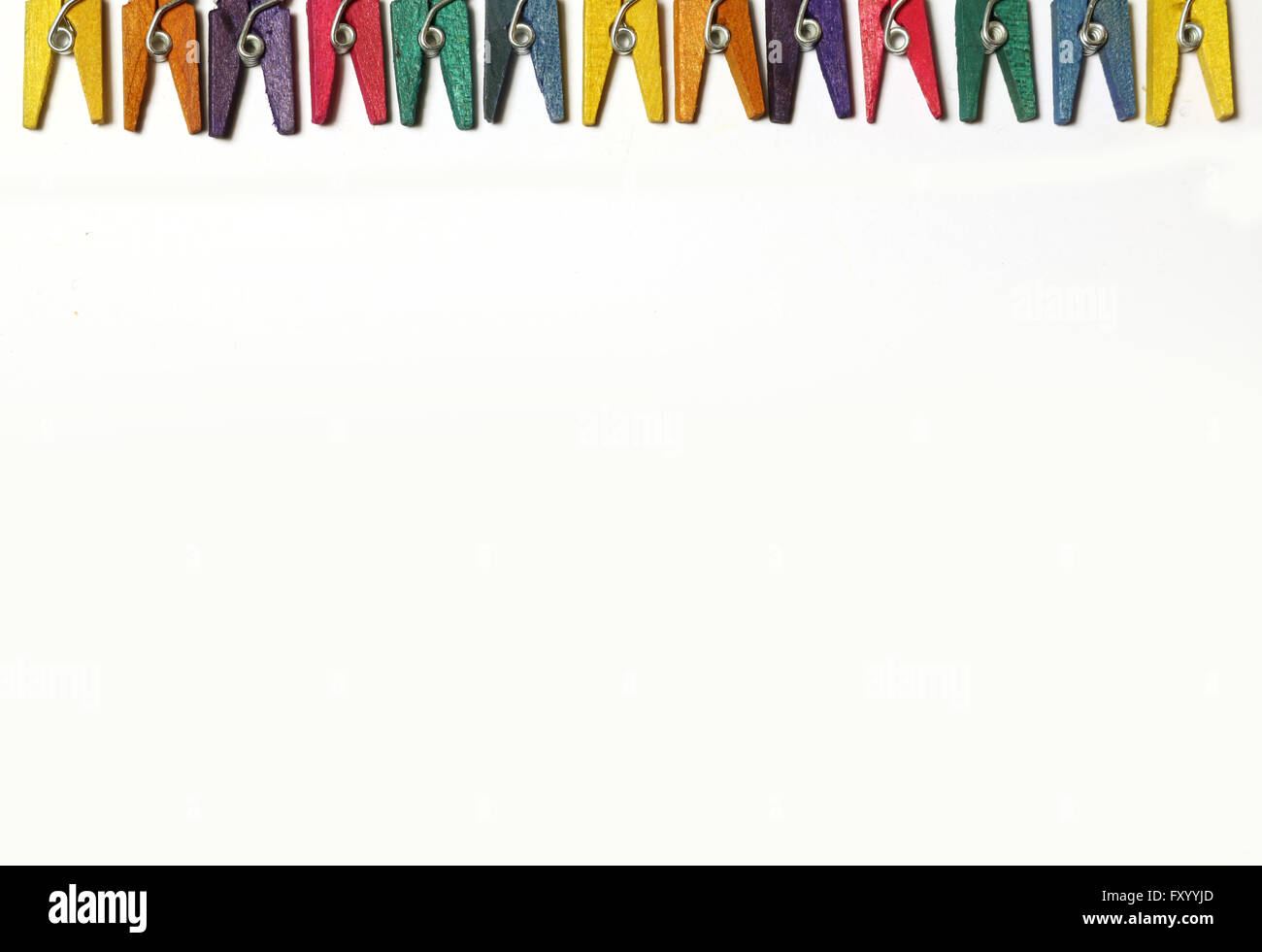 Mini colourful pegs on white background Stock Photo - Alamy