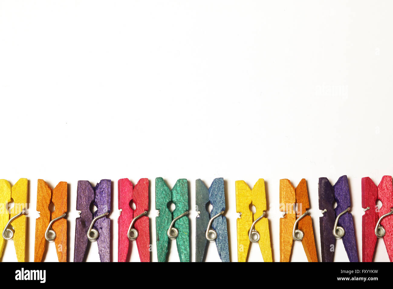 Mini colourful pegs on white background Stock Photo - Alamy