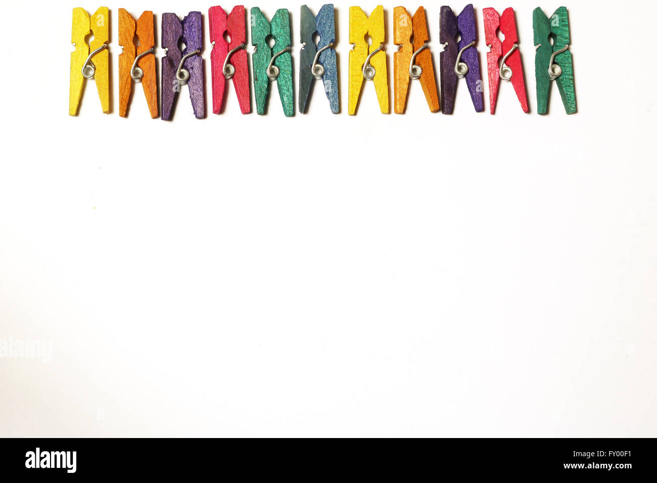 Mini colourful pegs on white background Stock Photo - Alamy