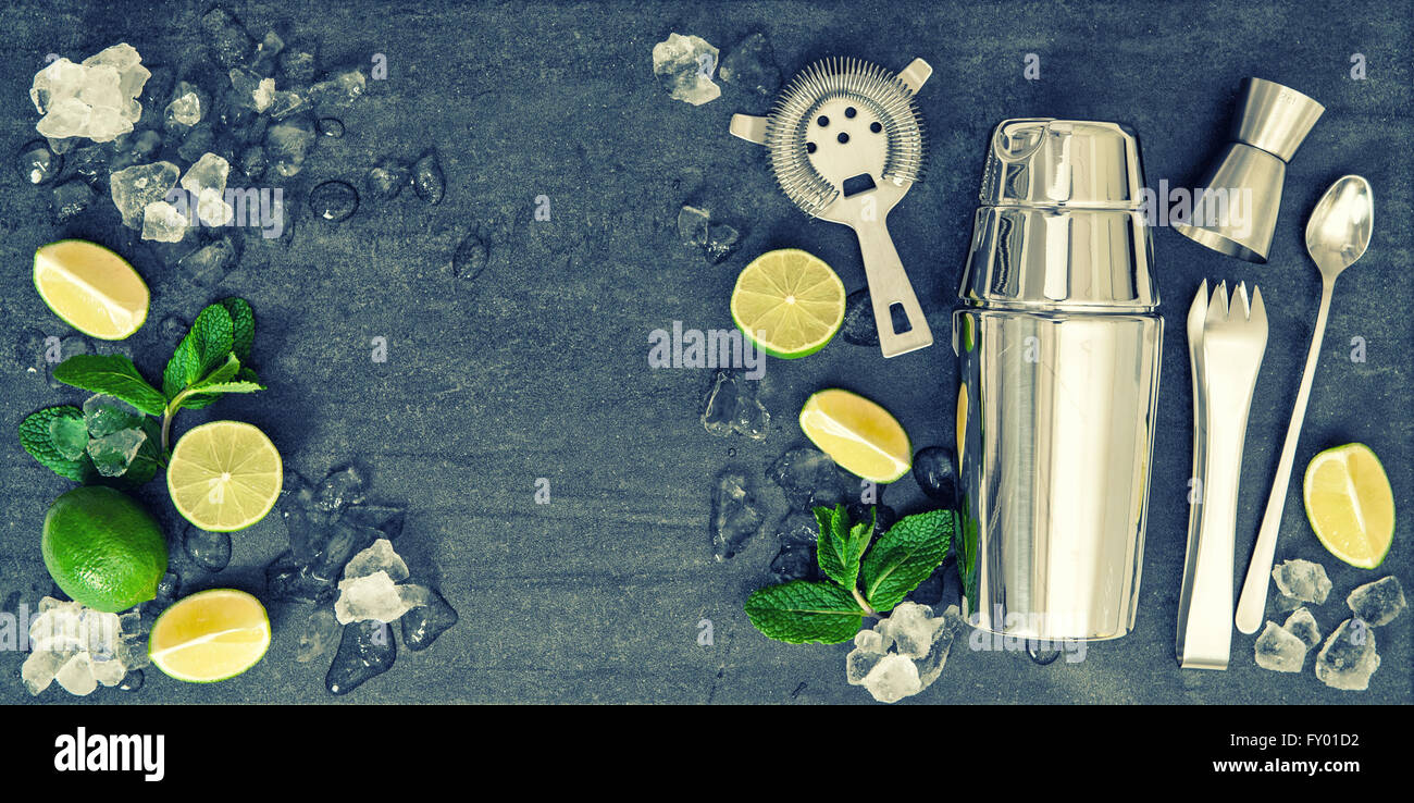 Bar accessories and ingredients for cocktail drink lime, mint, ice. Vintage style toned picture Stock Photo