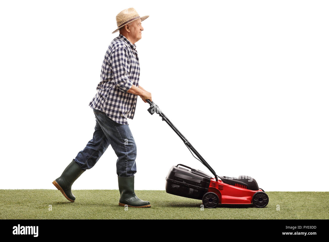 Profile shot of a mature gardener mowing a lawn with a lawnmower isolated on white background Stock Photo