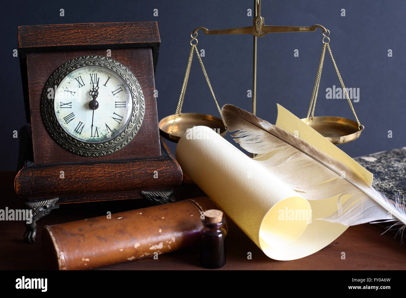 Vintage still life. Old table clock near scroll and other vintage things Stock Photo