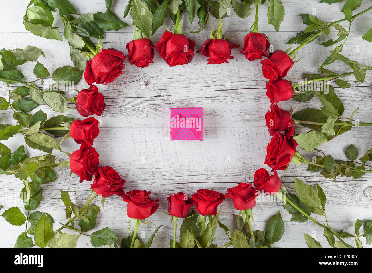 Circle Rustic Roses A bunch of red roses forming a circle on white rustic wooden table with ...