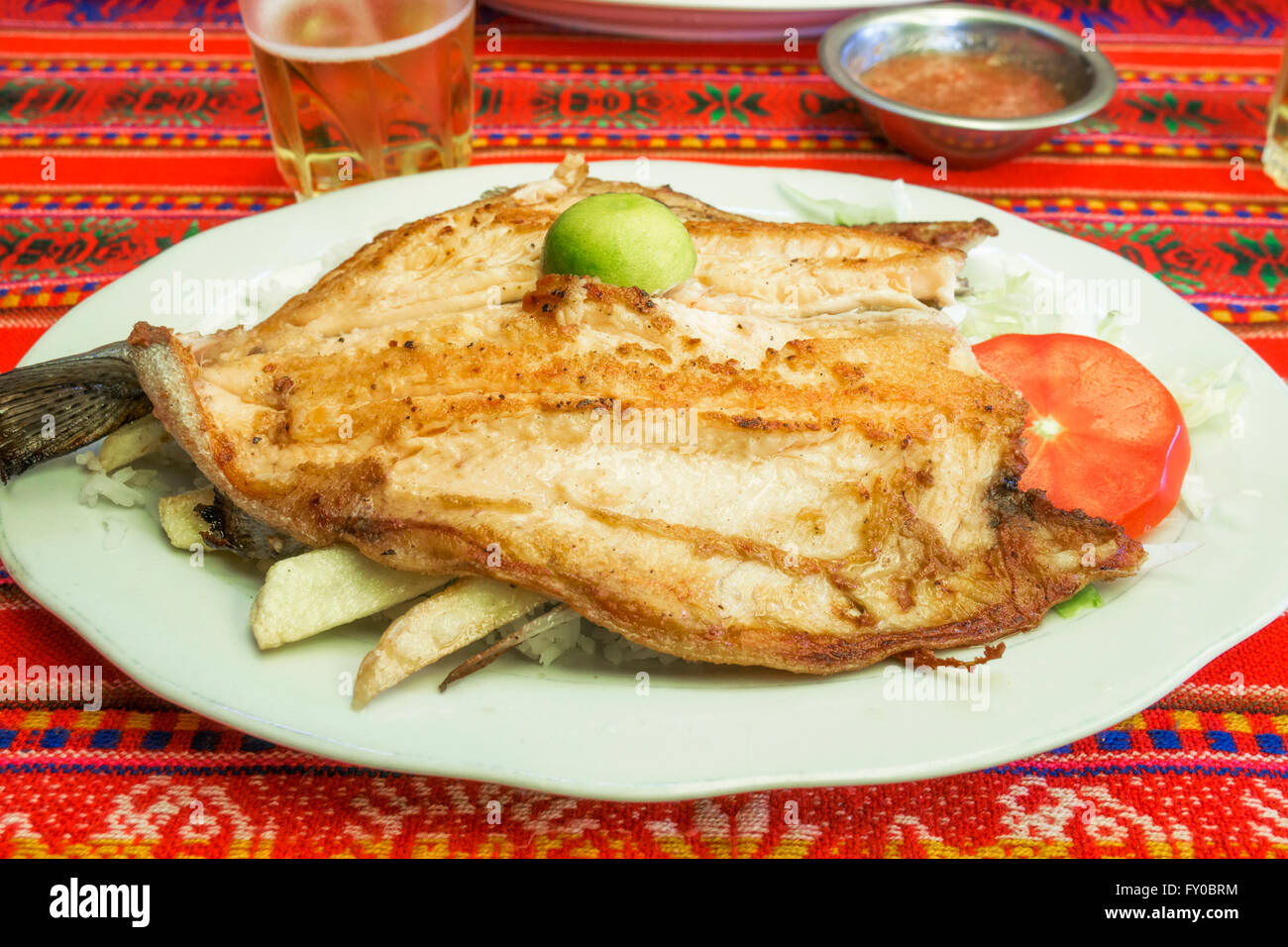 Authentic bolivian local grill fish plate with french fries, rice and salad in a simple street restaurant near Copacabana Stock Photo