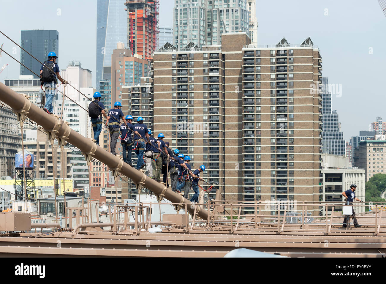 NEW YORK CITY, USA - JUNE 12, 2015: NYPD ESU officers climb down the brooklyn bridge Stock Photo