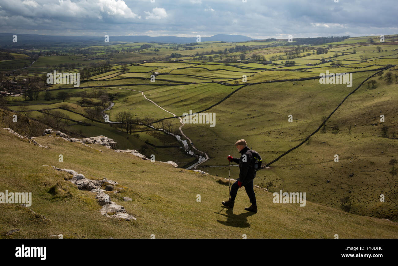 A walker follows a trail in Malham Cove in North Yorkshire, England, United Kingdom. Stock Photo