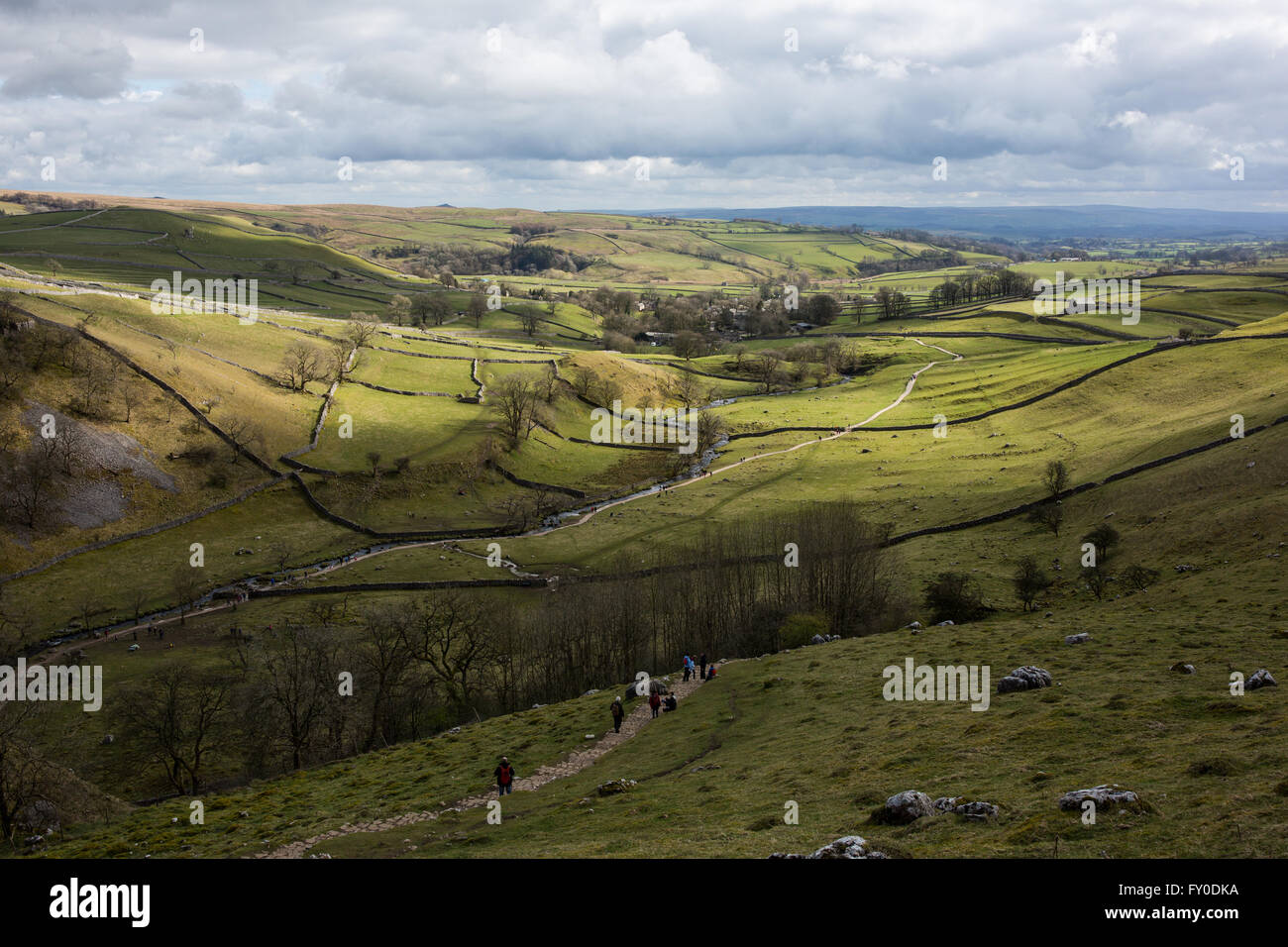 Walkers follow a trail in Malham Cove in North Yorkshire, England Stock