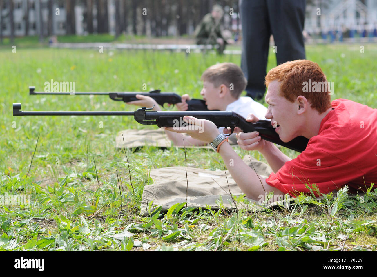 Military sports game Zarnitsa. Teenager shoots from an air rifle Stock