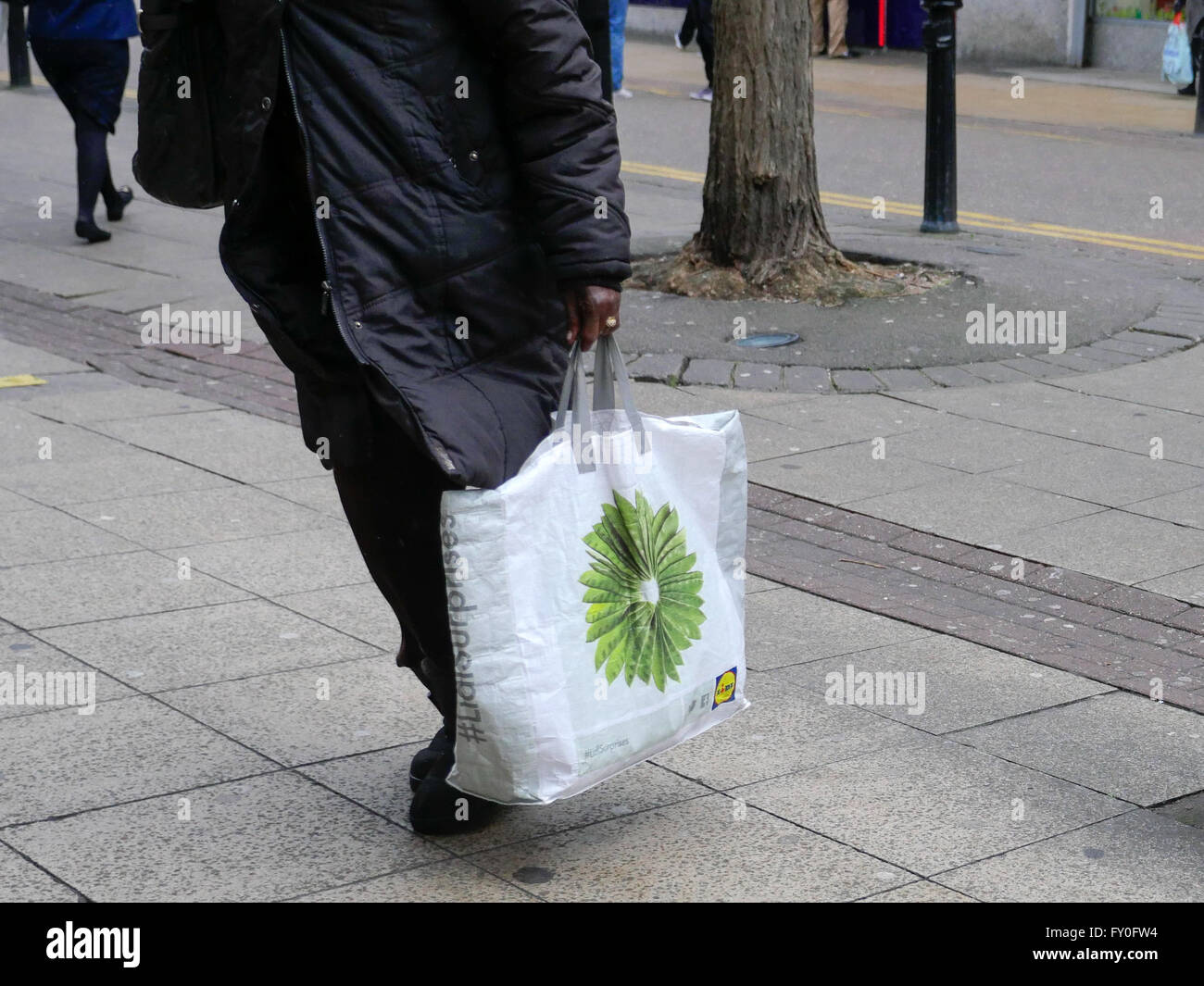 Lower body of a women carrying a Lidl shopping bag Stock Photo