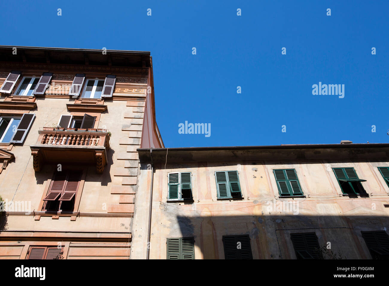 Painted frontages of Italian town houses in a tromp l'oiel style with blue sky Stock Photo