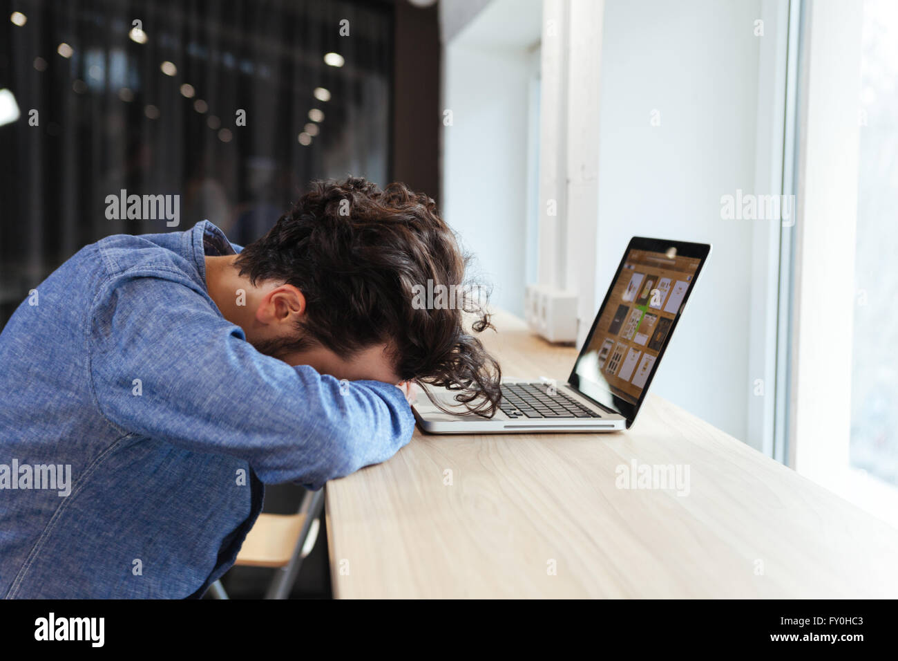 Businessman in casual cloth sleeping at the table with laptop computer in office Stock Photo