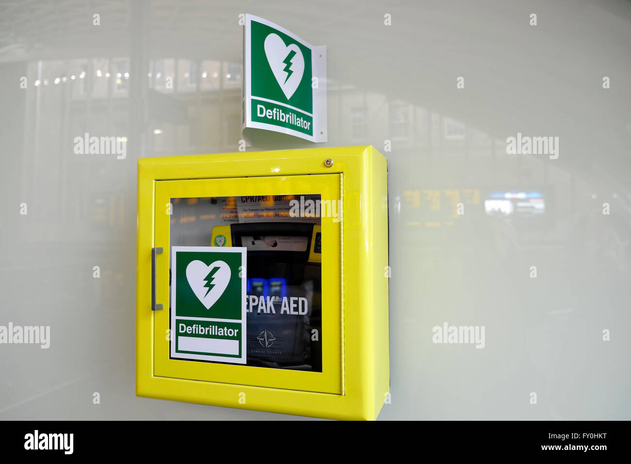 NHS defibrillator on wall in public area heart  sign symbol  'heart attack'  cardiac arrest emergency Stock Photo