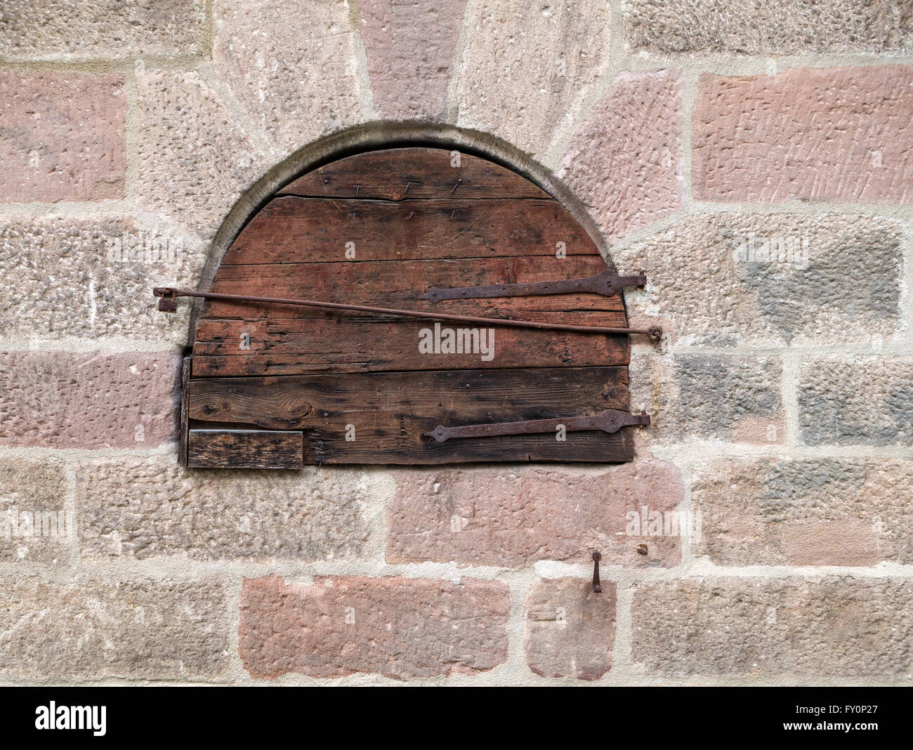 Round small wooden door in an old masonry Stock Photo