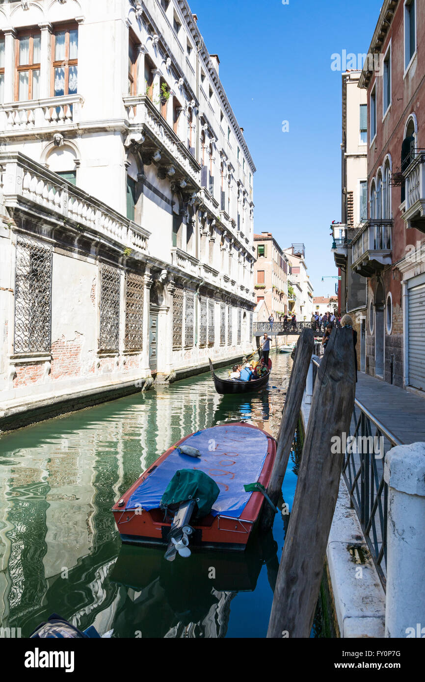 Venice,Italy-August 12,2014:Venetian gondoliers carry around some tourists  on a gondola in Venice During a sunny day inside her Stock Photo