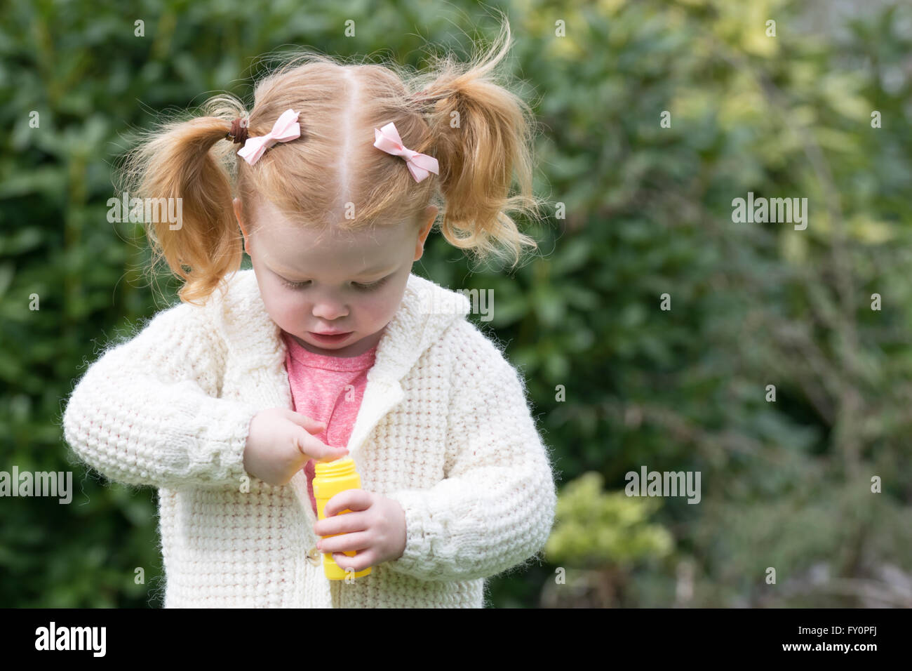 toddler girl playing with bubbles Stock Photo