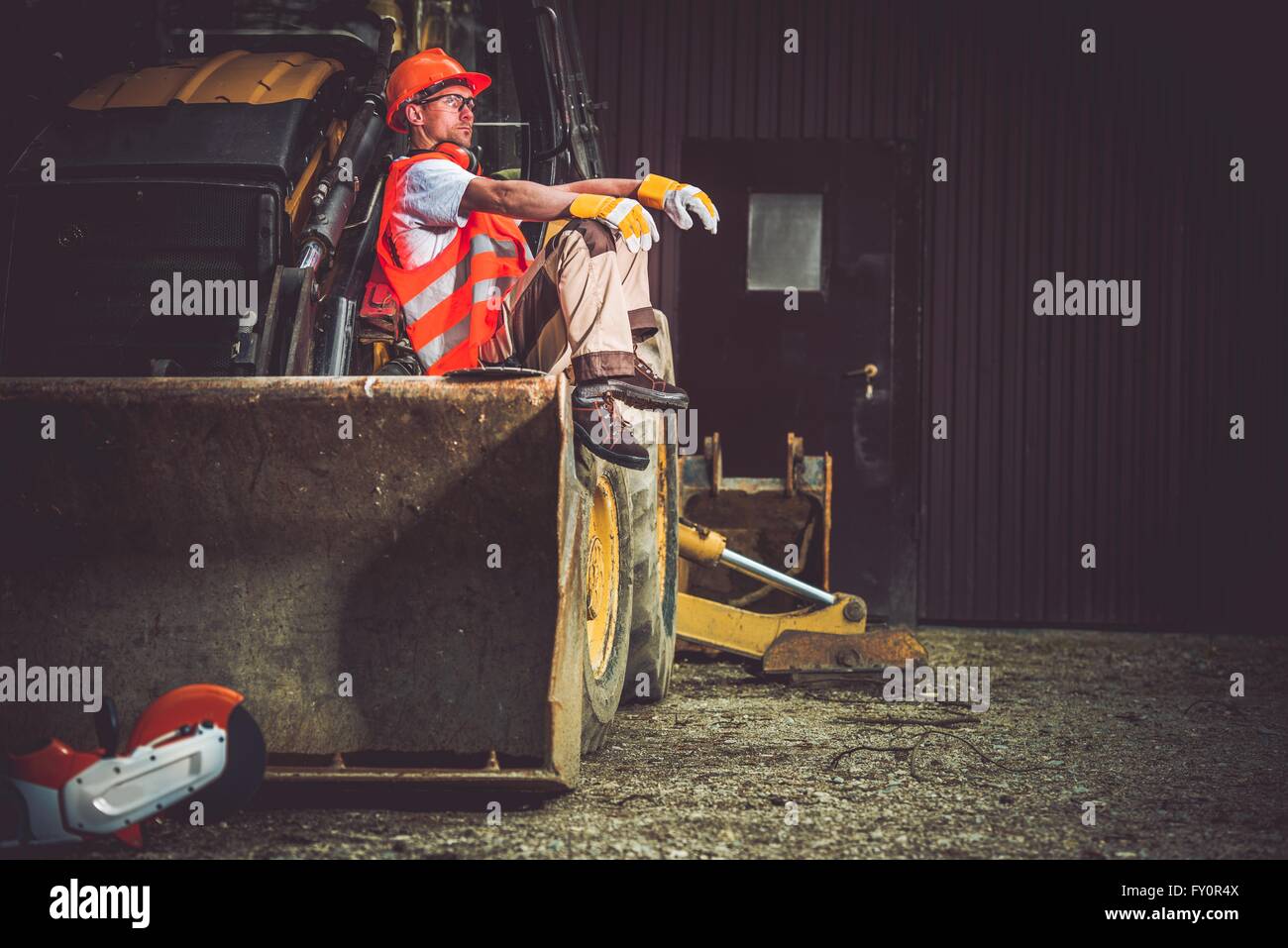 The Man and the Machine. Bulldozer and Excavator Operator Break at Work. Professional Caucasian Construction Machines Operator. Stock Photo