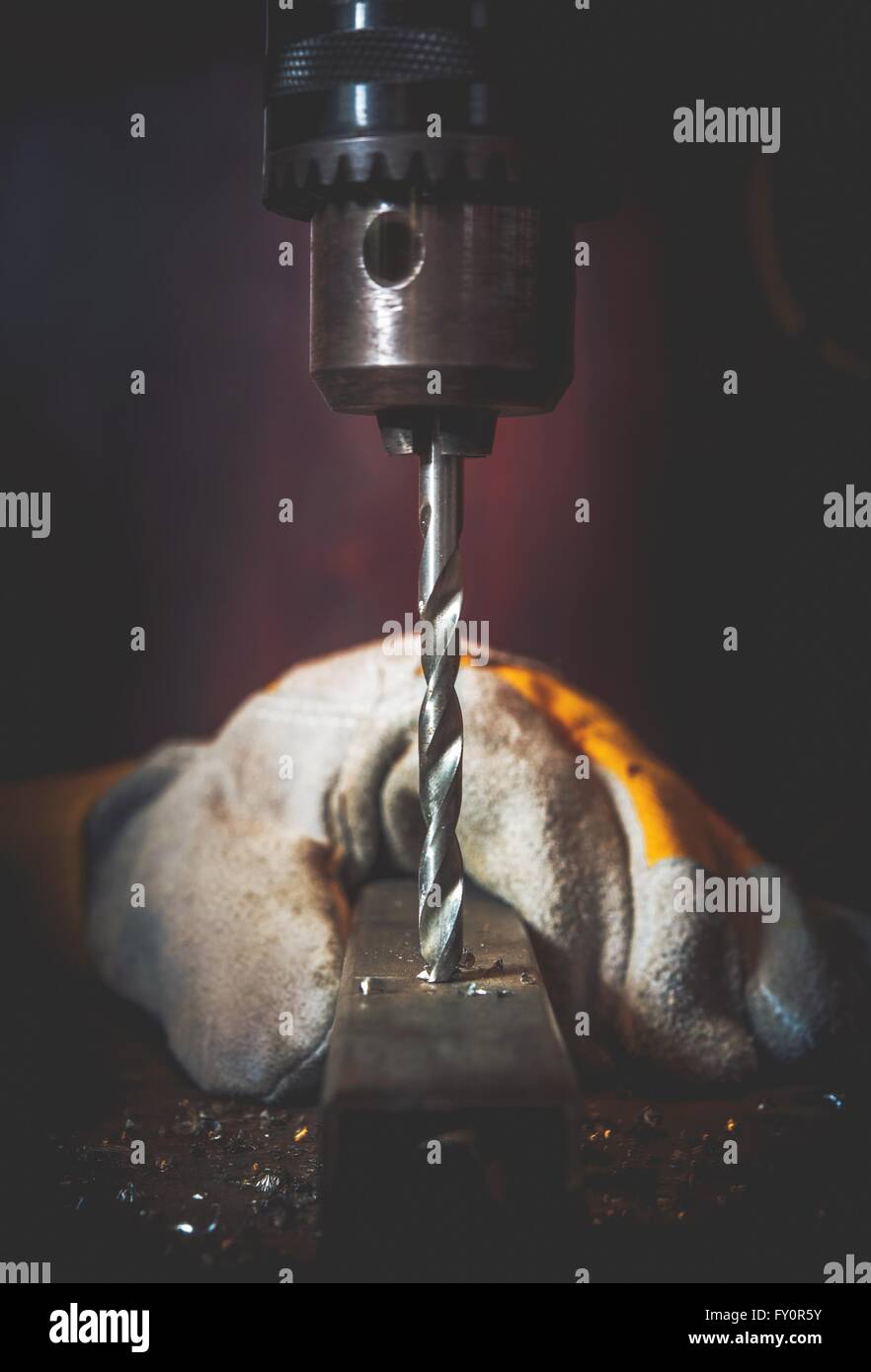 Metal Drilling Works Closeup Photo. Vertical Rotating Drill Bit Closeup