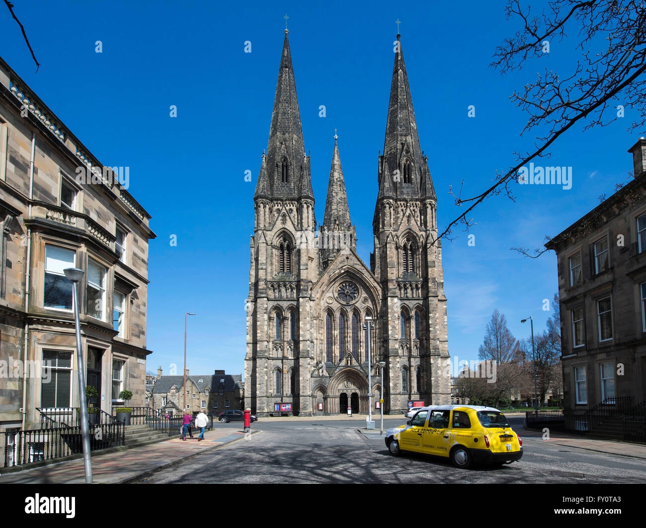 A yellow taxi  in front of St Mary's Cathedral in Palmerston Place, Edinburgh, Scotland, viewed from Grosvenor Crescent. Stock Photo