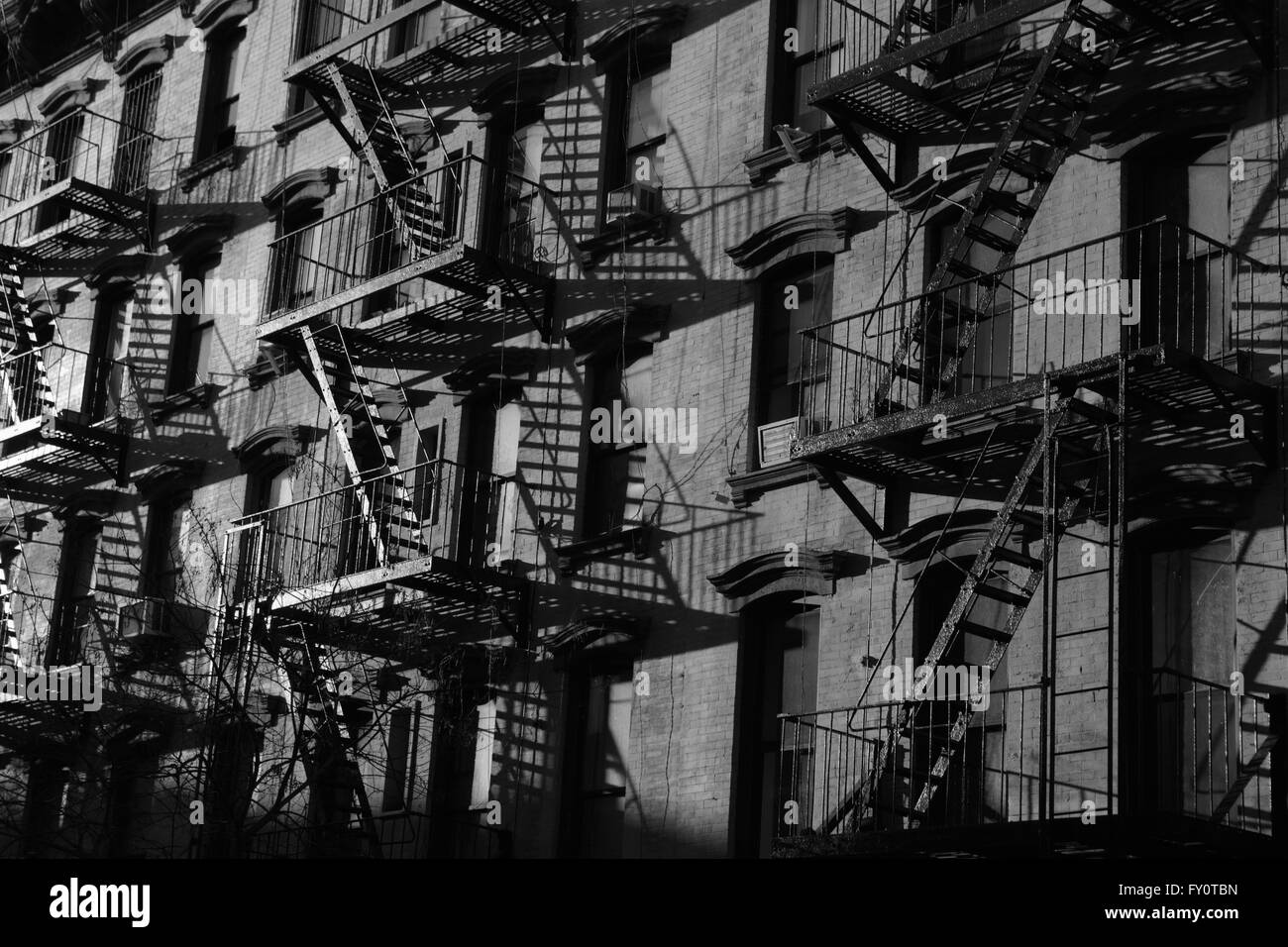 Fire escapes on old brick tenement building on Stanton Street, Lower East Side, New York City. Monochrome, black and white. Stock Photo