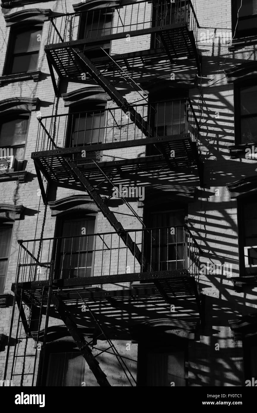Fire escapes on old brick tenement building on Stanton Street, Lower East Side, New York City. Monochrome, black and white. Stock Photo