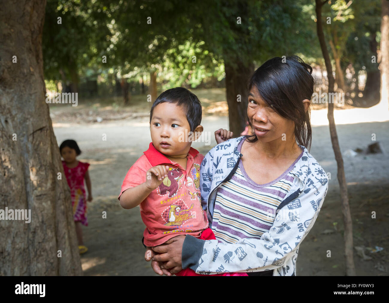 Local woman carrying her baby son in a village on the Irrawaddy River, Myanmar (Burma) Stock Photo