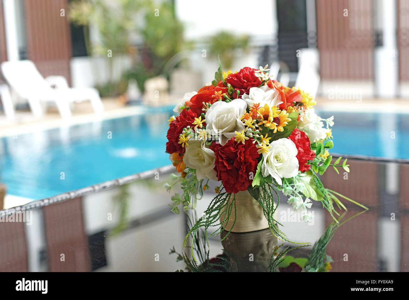 colorful artificial flower in vase on the table Stock Photo