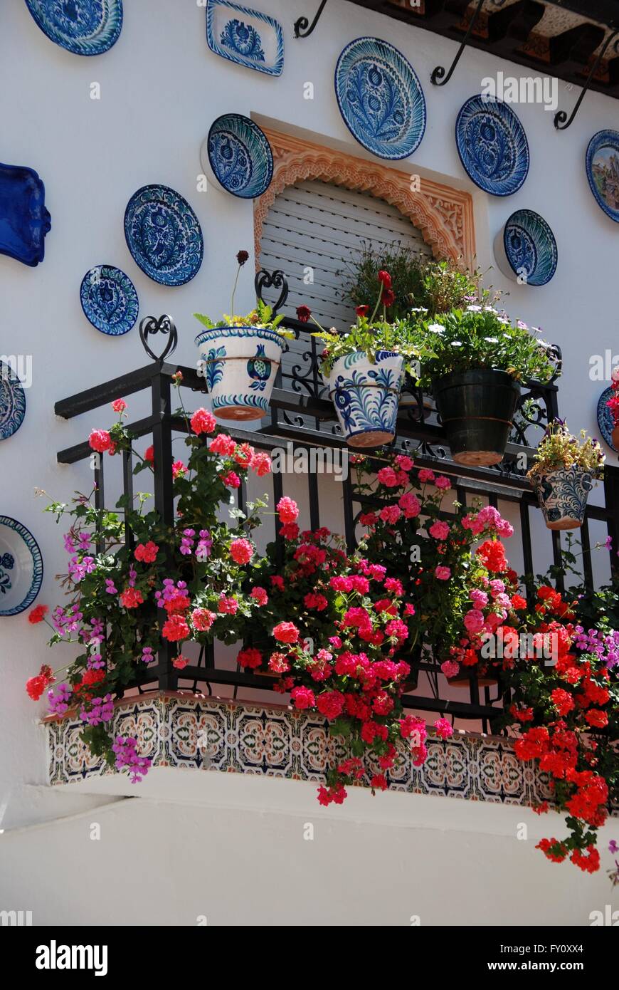 Wrought iron balcony on a traditional Spanish townhouse with assorted
