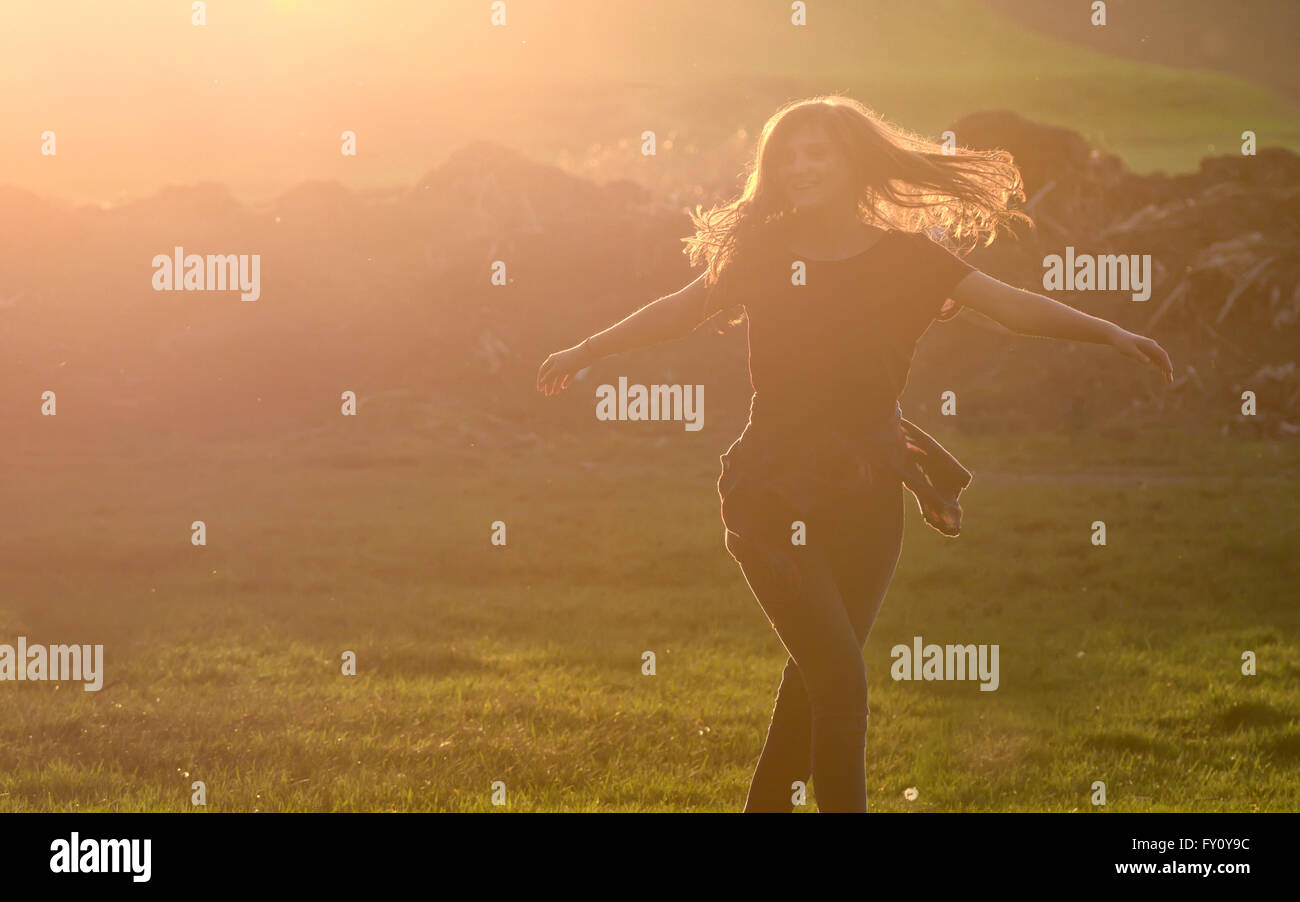 Teen girl jump against beautiful sunset in forest Stock Photo