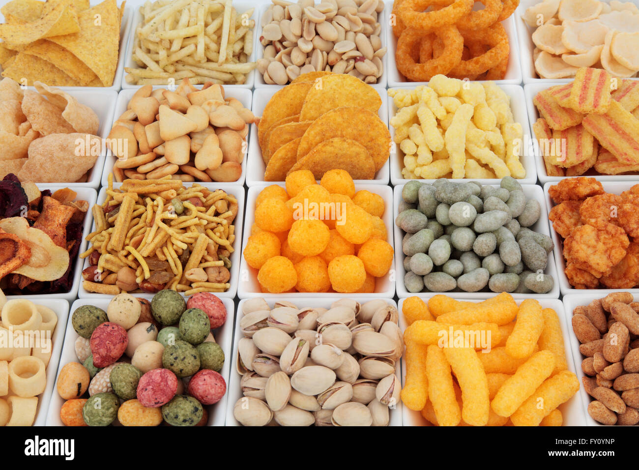Large savoury snack food selection in square porcelain bowls. Stock Photo