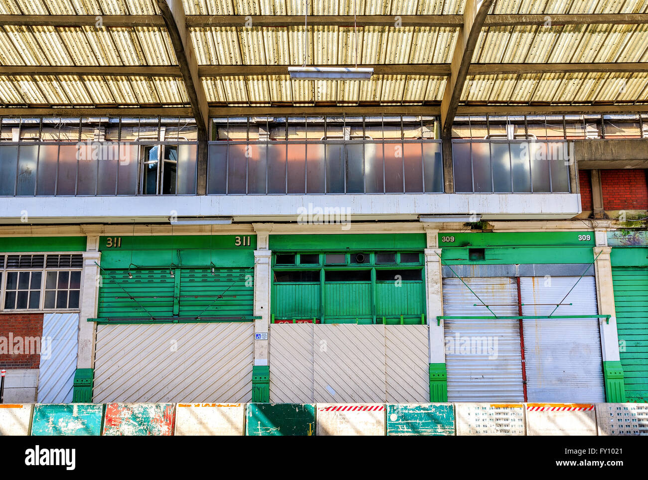 View of closed shops and old derelict building with plastic corrugated  roofing Stock Photo - Alamy