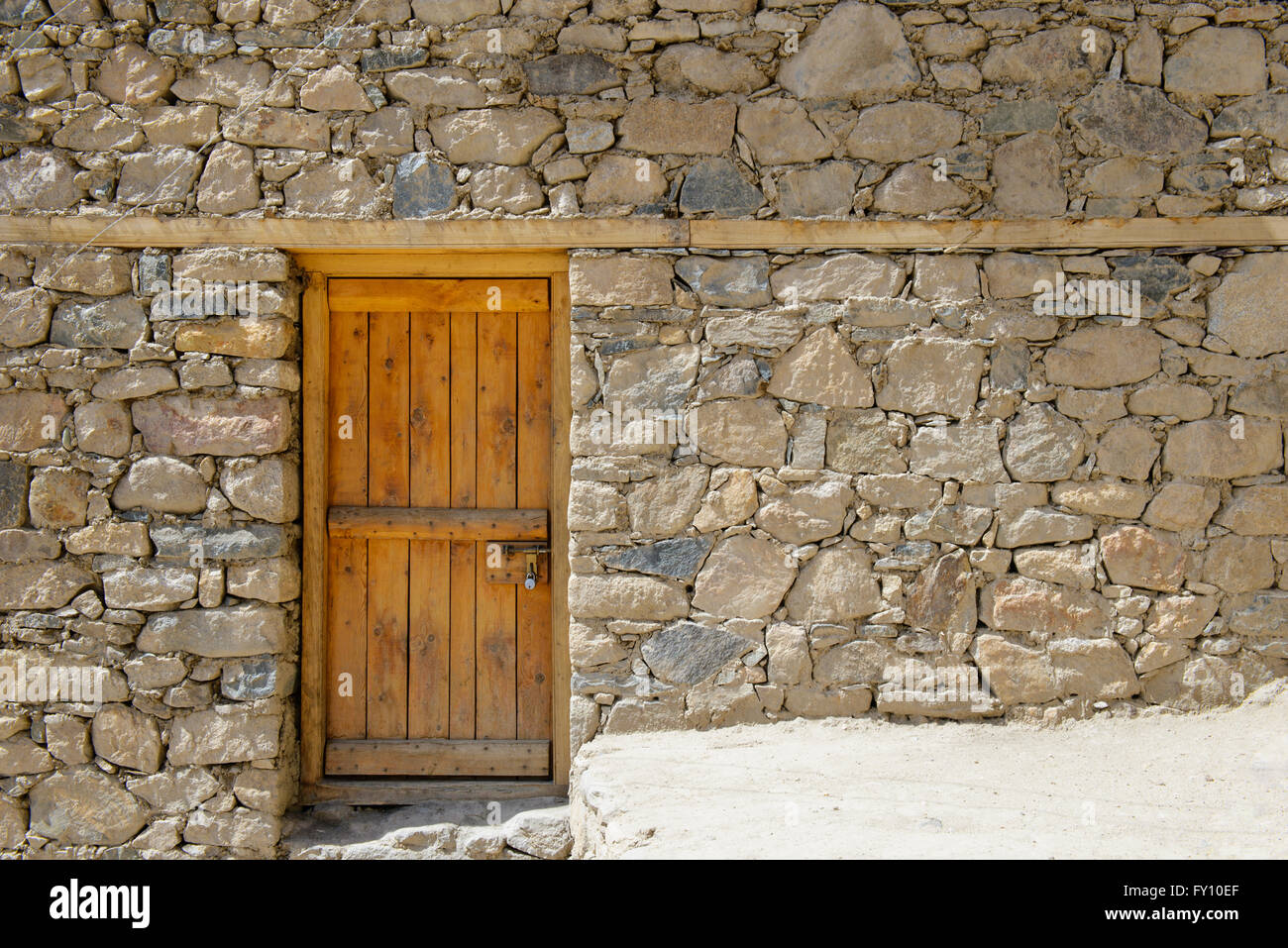 Old wooden door on stone wall Stock Photo - Alamy