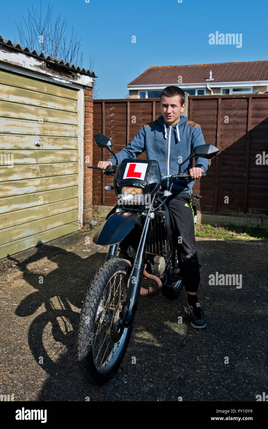 Model released image of a teenage boy to riding a motorbike. Stock Photo