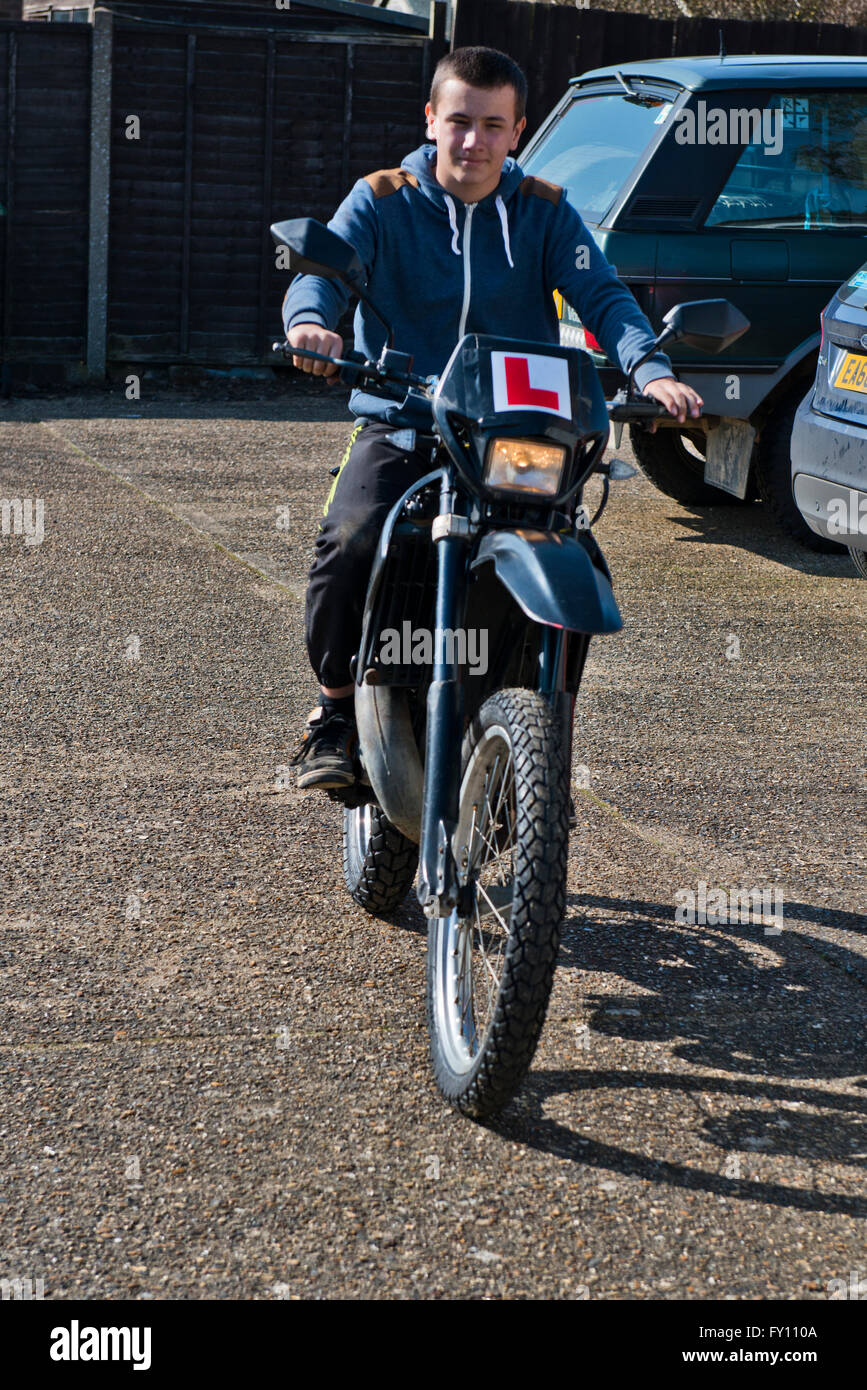 Model released image of a teenage boy to riding a motorbike. Stock Photo