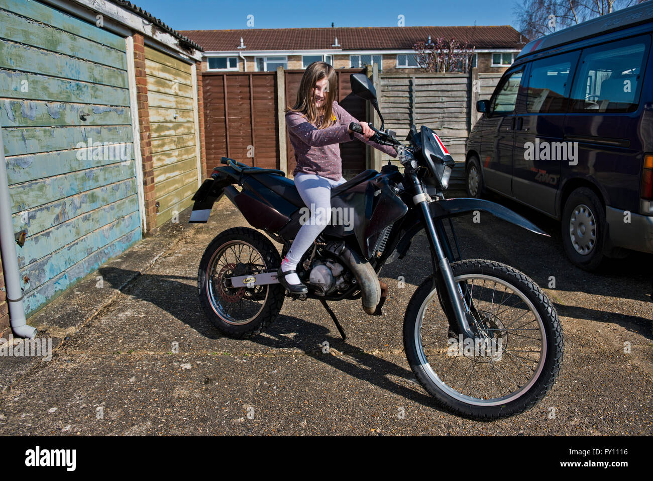Model released image of a young girl pretending to ride a motorbike. Stock Photo