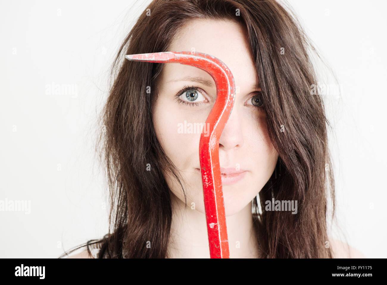 Woman holding crowbar. Portrait showing concept of fear, anxiety and self defense. Stock Photo