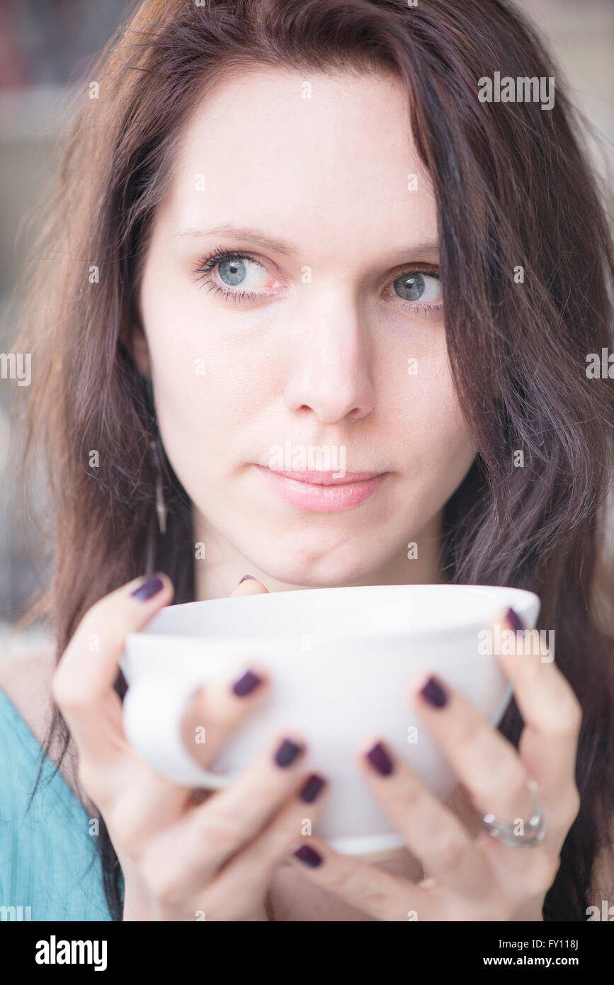 Woman holding tea cup in close up. Concept of thinking, waiting and anticipation. Lifestyle image of contemplation. Stock Photo