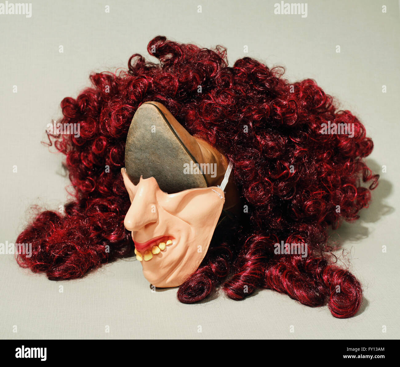 Face made from shoe, mask and wig over grey background Stock Photo